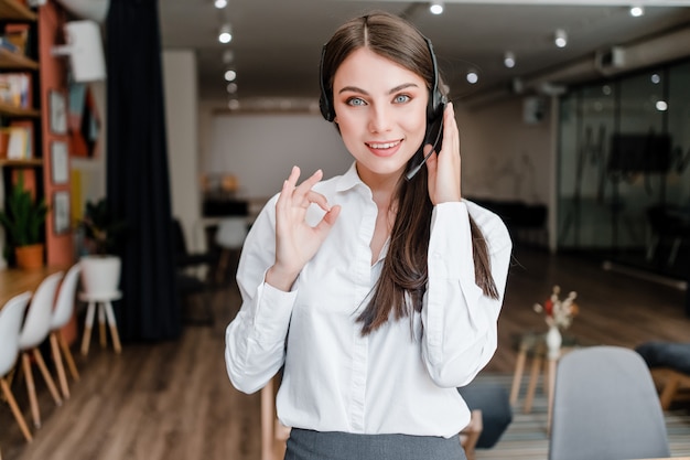 Mulher bonita que trabalha em call center no escritório mostrando que ela faz um bom trabalho