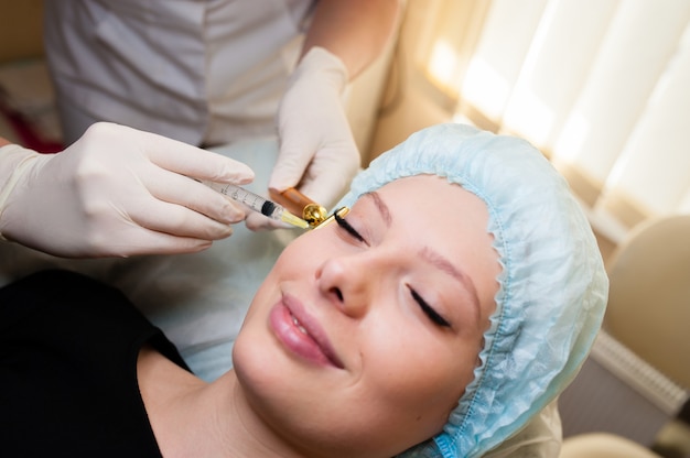 Mulher bonita recebendo injeção de levantamento nas maçãs do rosto. injeções de rejuvenescimento da pele. procedimentos cosméticos, injeções.