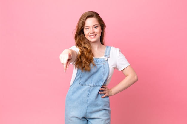 Mulher bonita ruiva apontando para a câmera escolhendo você