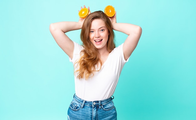 Mulher bonita ruiva. conceito de suco de laranja