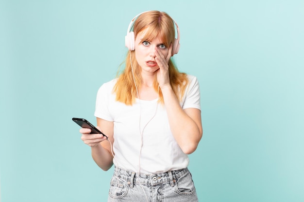 Mulher bonita ruiva se sentindo entediada, frustrada e com sono após uma música cansativa e ouvindo com fones de ouvido