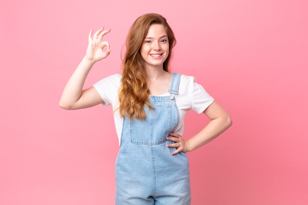 Mulher bonita ruiva se sentindo feliz, mostrando aprovação com gesto de ok