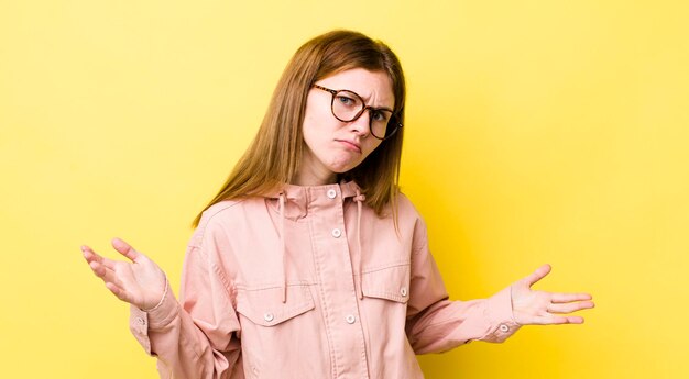 Mulher bonita ruiva se sentindo sem noção e confusa, sem ideia absolutamente confusa com um olhar idiota ou tolo