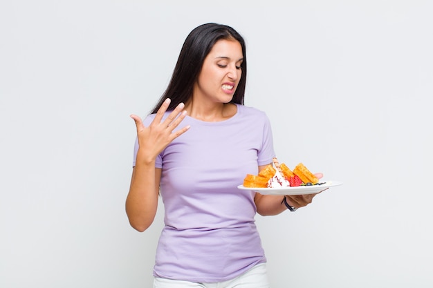 Mulher bonita se sentindo estressada, ansiosa, cansada e frustrada, puxando o pescoço da camisa, parecendo frustrada com o problema