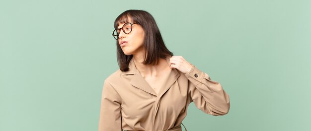 Mulher bonita se sentindo estressada, ansiosa, cansada e frustrada, puxando o pescoço da camisa, parecendo frustrada com o problema