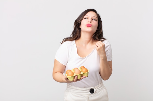 Mulher bonita se sentindo estressada, ansiosa, cansada e frustrada segurando uma caixa de ovos