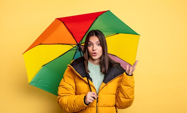 Mulher bonita se sentindo extremamente chocada e surpresa. conceito de inverno e guarda-chuva