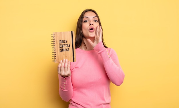 Mulher bonita se sentindo feliz dando um grande grito com as mãos ao lado do conceito de reciclagem da boca