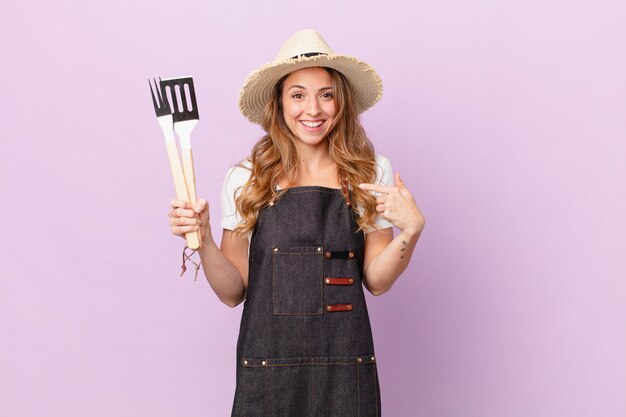 Mulher bonita se sentindo feliz e apontando para si mesma com um animado. conceito de chef de churrasco