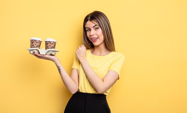 Mulher bonita se sentindo feliz e enfrentando um desafio ou celebrando o conceito de cafés para viagem