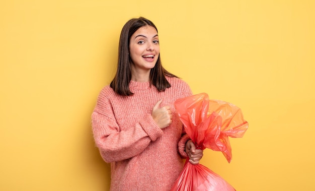 Mulher bonita se sentindo feliz e enfrentando um desafio ou comemorando. conceito de saco de lixo