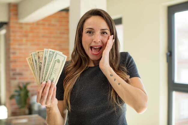 mulher bonita se sentindo feliz e surpresa com algo inacreditável conceito de notas de dólar