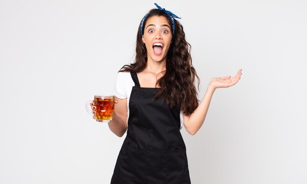 Mulher bonita se sentindo feliz e surpresa com algo inacreditável e segurando uma caneca de cerveja