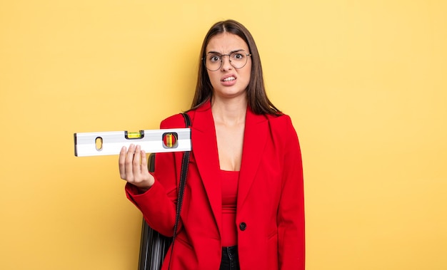 Mulher bonita se sentindo intrigada e confusa. arquiteto com nível