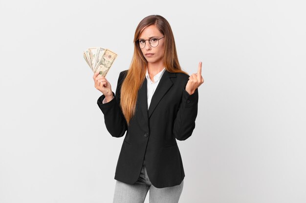 Mulher bonita se sentindo irritada, irritada, rebelde e agressiva. conceito de negócios e dólares