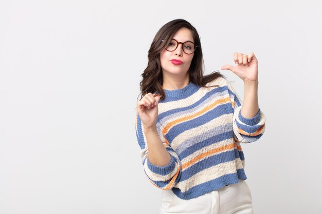 Mulher bonita se sentindo orgulhosa, arrogante e confiante, parecendo satisfeita e bem-sucedida, apontando para si mesma