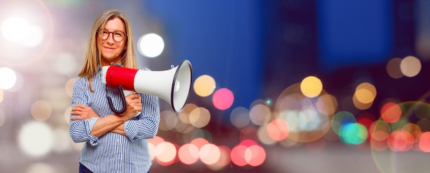 Mulher bonita sênior com um megafone