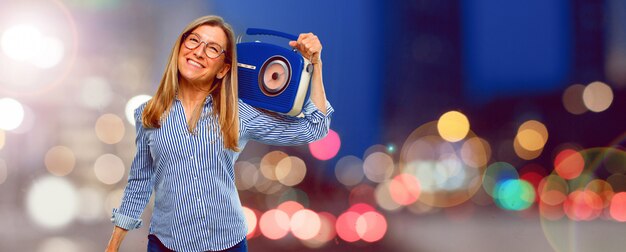 Mulher bonita sênior com um rádio vintage