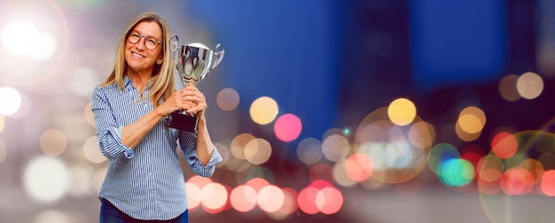 Mulher bonita sênior com um troféu