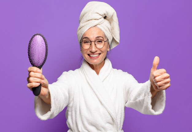 Mulher bonita sênior com uma escova de cabelo