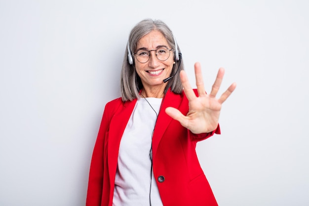 Mulher bonita sênior sorrindo e parecendo amigável, mostrando o número cinco. conceito de telemarketing