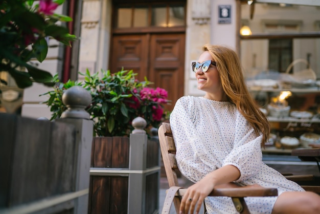 Mulher bonita sentada à mesa num café na rua da cidade Pessoas de moda, estilo de vida, conceito de viagem