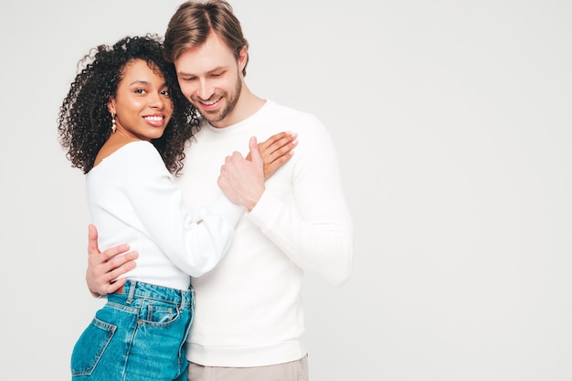 Foto mulher bonita sorridente e seu namorado bonito. família alegre e multirracial feliz tendo momentos de ternura em cinza