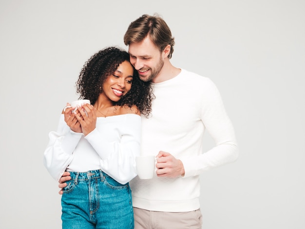 Mulher bonita sorridente e seu namorado bonito. família alegre e multirracial feliz tendo momentos de ternura em cinza