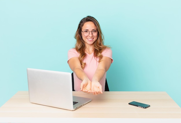 Mulher bonita sorrindo alegremente com amigável e oferecendo e mostrando um conceito. conceito de teletrabalho