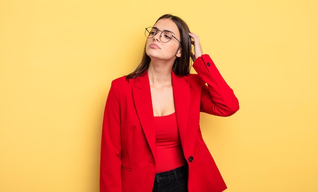 Mulher bonita sorrindo alegremente e sonhando acordado ou duvidando. conceito de empresária