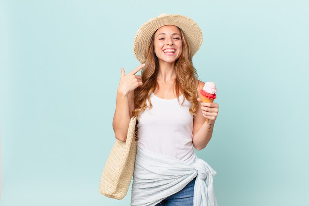 Mulher bonita sorrindo com confiança, apontando para o próprio sorriso largo. conceito de verão