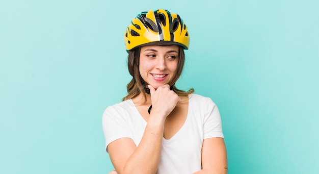 Mulher bonita sorrindo com uma expressão feliz e confiante com a mão no queixo