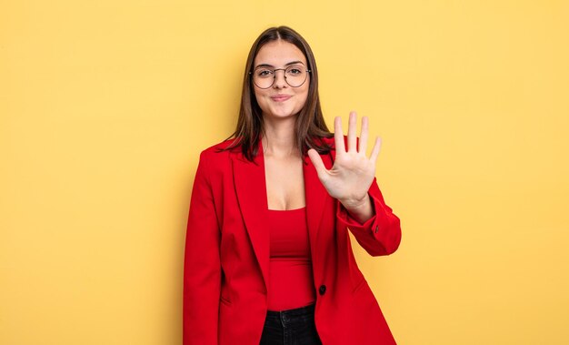 Mulher bonita sorrindo e parecendo amigável, mostrando o número cinco. conceito de empresária