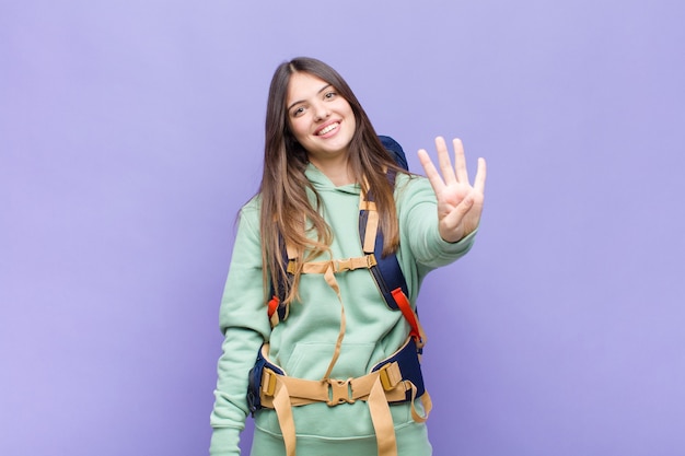 Mulher bonita sorrindo e parecendo amigável mostrando o número quatro