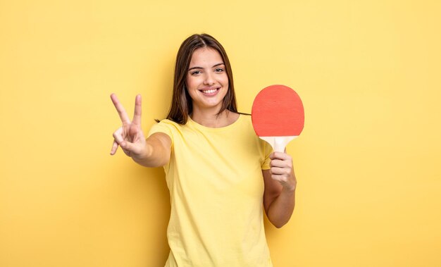 Mulher bonita sorrindo e parecendo feliz, gesticulando vitória ou paz. conceito de pingue-pongue