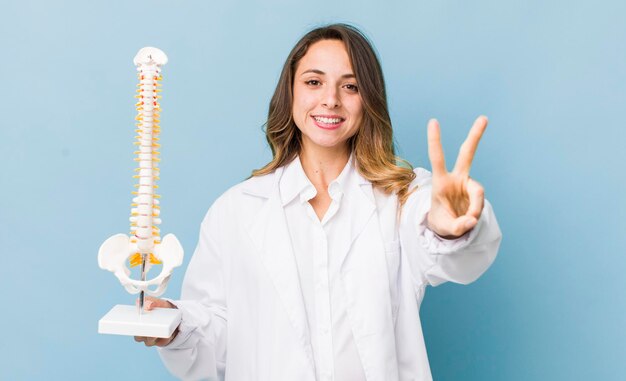 Foto mulher bonita sorrindo e parecendo feliz gesticulando vitória ou paz