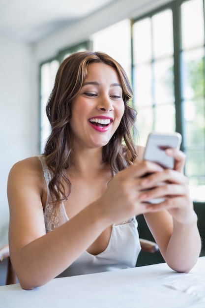 Mulher bonita sorrindo enquanto estiver usando seu telefone celular