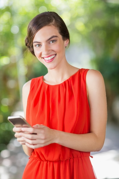 Mulher bonita sorrindo enquanto estiver usando telefone celular