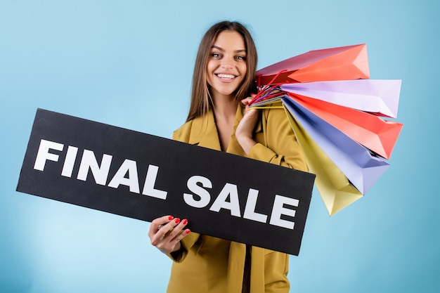 Mulher bonita sorrindo segurando bandeira preta venda final e sacolas coloridas