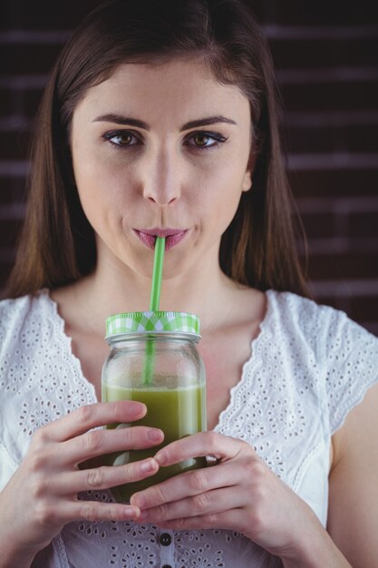 Foto mulher bonita tomando suco verde