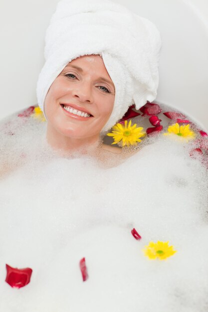 Mulher bonita tomando um banho relaxante com uma toalha na cabeça