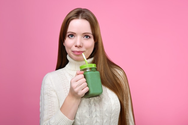 Mulher bonita tomando um smoothie verde