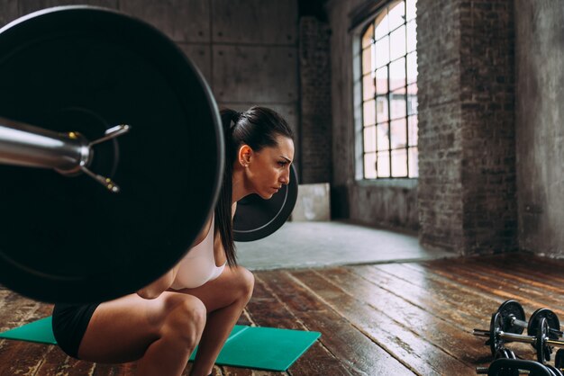 Mulher bonita treinando e fazendo exercícios funcionais na academia