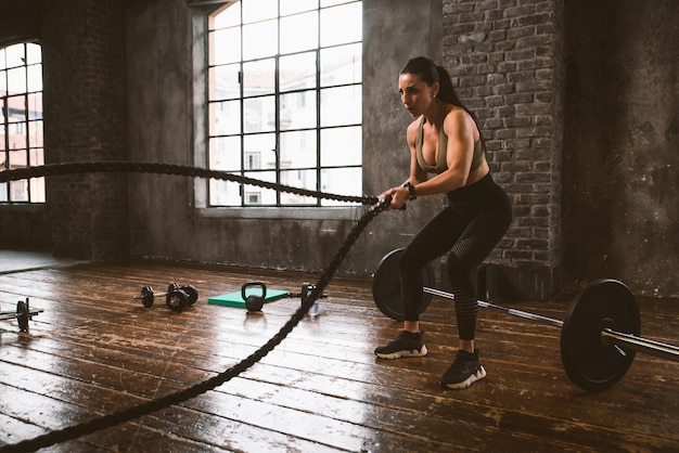 Mulher bonita treinando e fazendo exercícios funcionais na academia