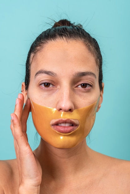 Mulher bonita usando máscara facial com gel de colágeno