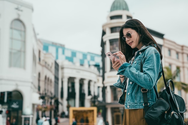 mulher bonita usando smartphone para pesquisar a localização de sua loja de bolsas favorita