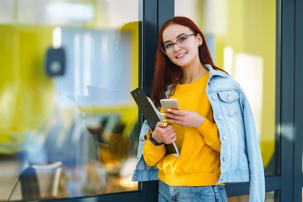 Mulher bonita usando telefone no prédio de escritórios moderno Jovem freelancer trabalhando no escritório