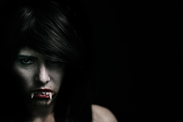 Mulher bonita vampira de Halloween sobre preto