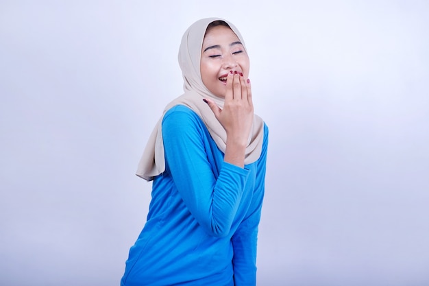 Mulher bonita vestindo camiseta azul e hijab sorrindo fecha os olhos