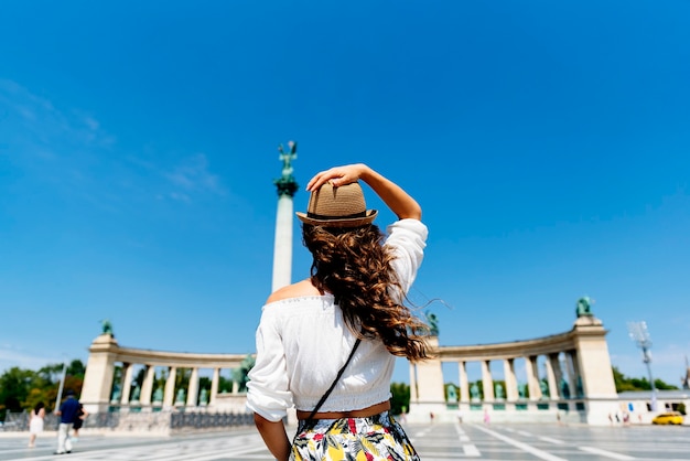 Foto mulher bonita viajando por budapeste - praça dos heróis. conceito de turismo.